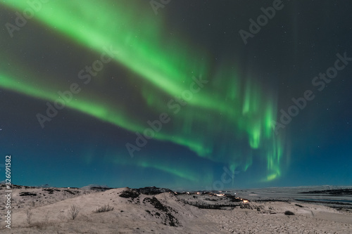 A beautiful northern lights also called Aurora Borealis over the Iceland. Winter time in Scandinavia is very magical and brings a lot of tourists from all over the world to see it