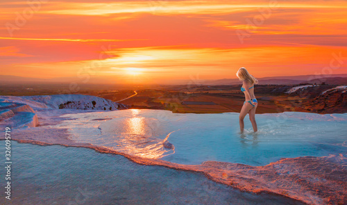 Natural travertine pools and terraces in Pamukkale. Cotton castle - Young girl is walking on the travertines  © muratart