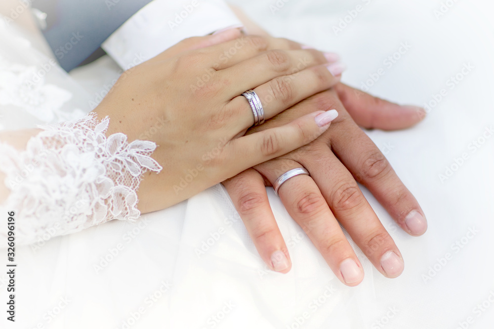 Hands and rings on wedding bouquet