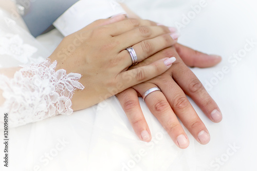 Hands and rings on wedding bouquet