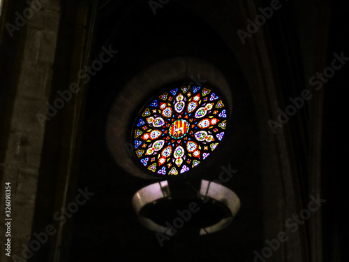Spain  Cervera - October 10  2018  Round stained glass window with the flag of Catalonia at Collegiate church of Santa Maria in Cervera. Blue-red-yellow glass pattern isolated on a black background
