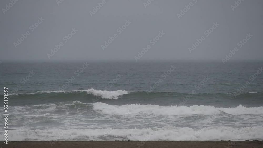 Afternoon views of tropical beaches can be seen soft waves moving in and out in summer season.Flock of birds flying through on background. Afternoon views of tropical beaches can be seen soft waves moving in and out in summer season.Flock of birds flying through on background.