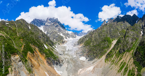 Caucasus Mountains on the border of Russia and Georgia. Chalaat Pass and Very beautiful view of the Chalaadi Glacier, Mount Ushba and Mestiachala river with background of clear blue sky. photo