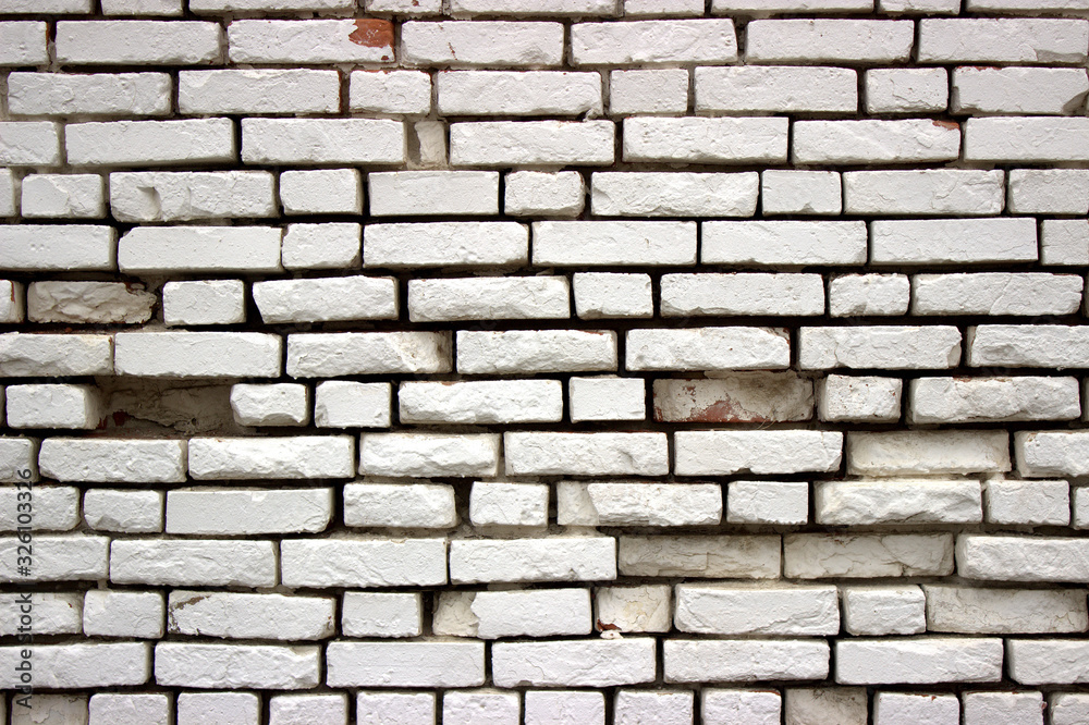 Fototapeta premium Photo of a white brick wall with bricks grazing in several places. Retro