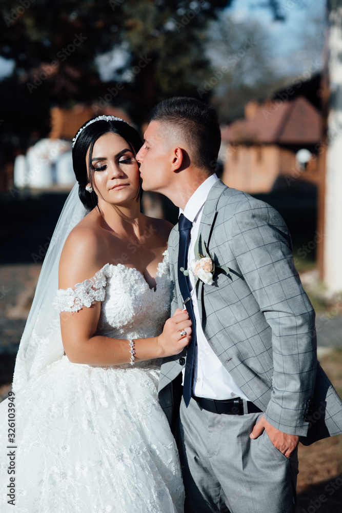 Fototapeta premium Bride and groom kisses tenderly. Beautiful pictures. Guys enjoy. Sexy kissing stylish couple of lovers close up portrait
