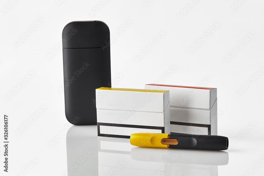 Obraz premium Black and yellow electronic cigarette, battery, two packs and one of them with red side, isolated on white. Heating tobacco system. Close up