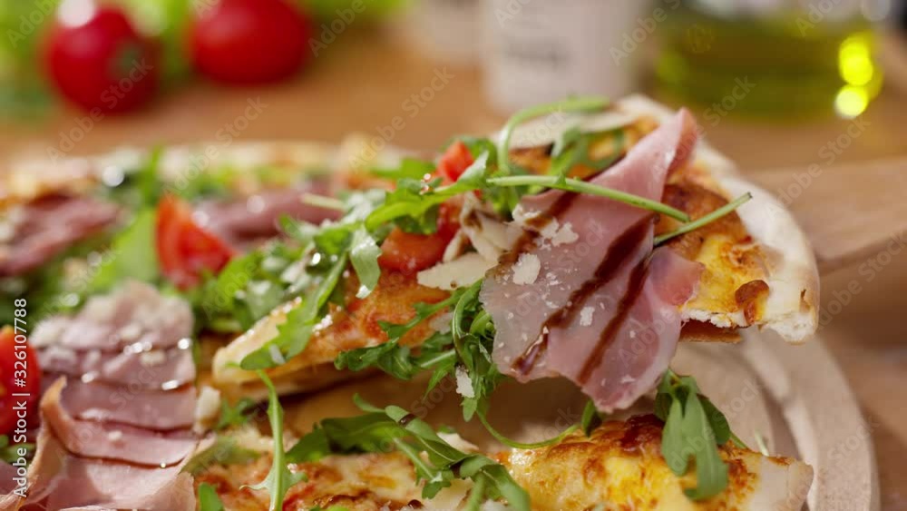 Close up wooden spoon taking pizza slice with tomato ham arugula hot melted cheese is stretching fast-food concept delicious meal closeup crust restaurant tasty fresh cuisine eat dinner mozzarella