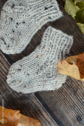 Chunky and warm baby socks on dar wooden background