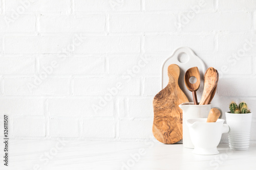 Kitchen utensils on a background of a white brick wall. Concept of the decor of the kitchen.