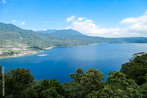 A panoramic view on The Twin Lake  Bali  Indonesia. The lake is surrounded by lush green plants. There are small hills all around the lake. Touristic attraction. Biggest lake on Bali