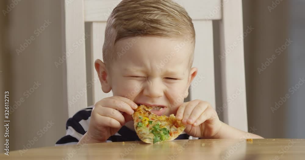 Little Boy Eating Pizza Enjoying the Taste and Smiling a Portrait Shot on Red Camera Little Boy Eating Pizza Enjoying the Taste and Smiling a Portrait Shot on Red Camera