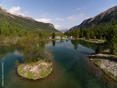 Fototapeta Naklejka Na Ścianę i Meble -  PONTRESINA, SWITZERLAND - JUNE 4, 2015: Little lake with the island in the region of swiss glacier Morteratsch.