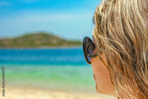 happy girl with sunglasses by the sea on nature background