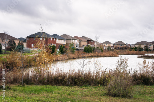 Park with a pond in a new housing develpoment in Ontario, Canada, on an overcast autumn day