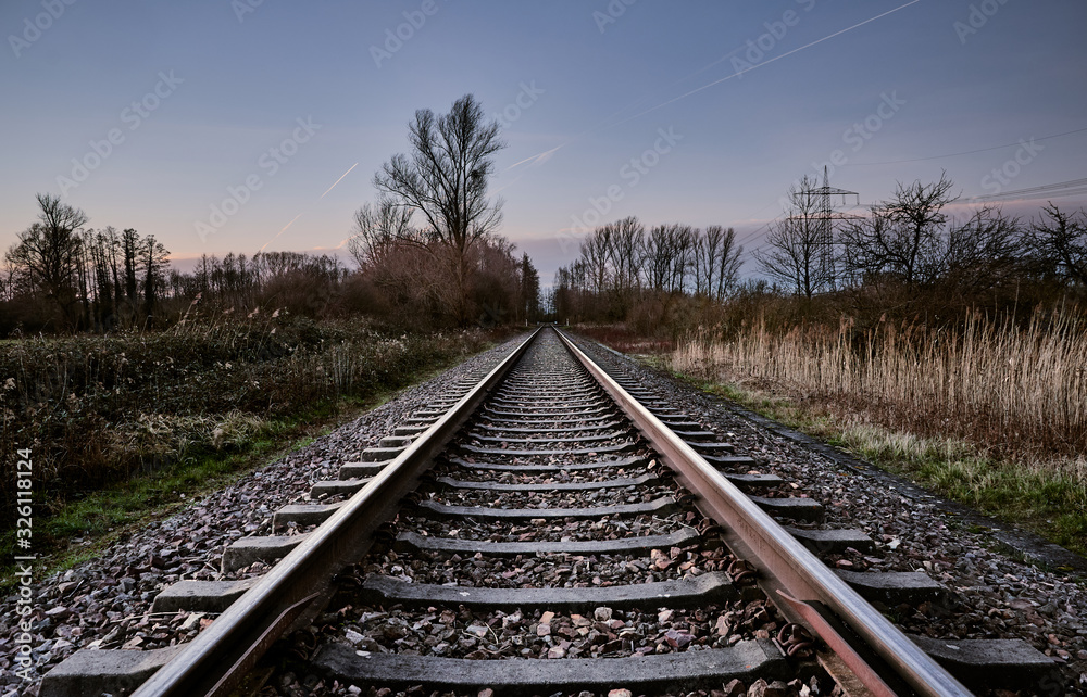 Railroad track in a rural area in front of the blue sky