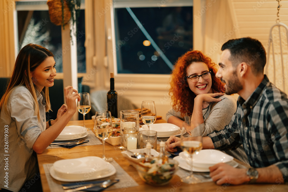 Happy friends talking while having dinner in dining room. Happy friends talking while having dinner in dining room.
