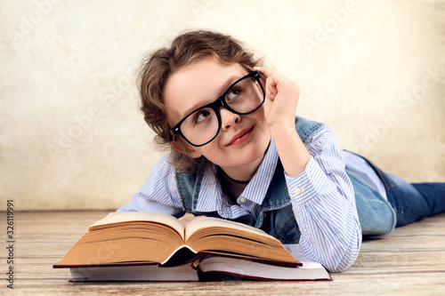 Young pretty and smart girl wearing glasses reading a book photo