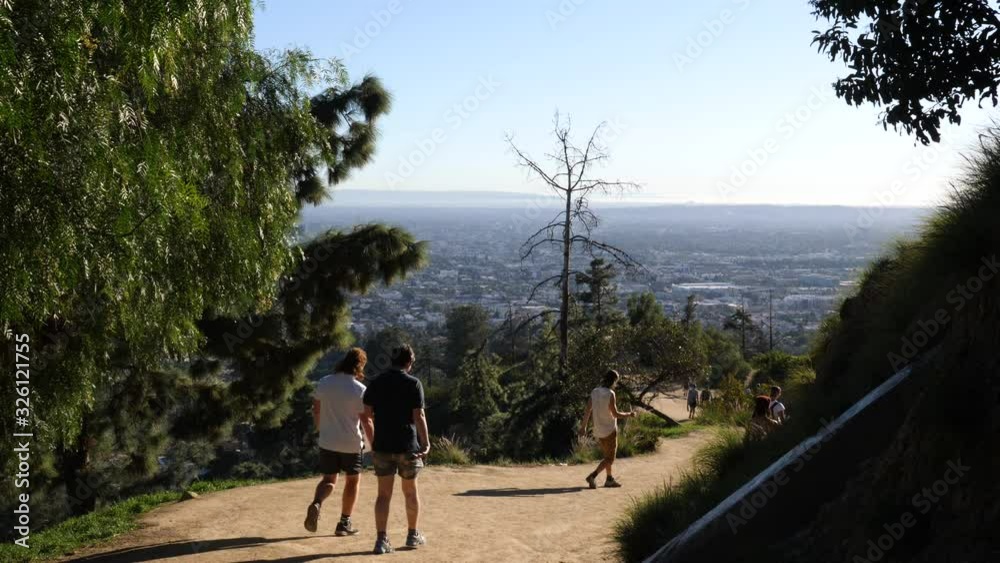 A view of hikers trekking down the Hollywood Hills overlooking Los Angeles, California. A view of hikers trekking down the Hollywood Hills overlooking Los Angeles, California.