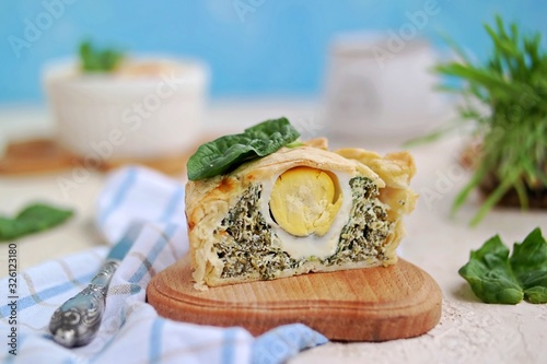 Portioned traditional Italian Easter cake or tart with spinach, ricotta and whole eggs. Italian food. Dishes Easter. Baking with greens. Selective focus. photo