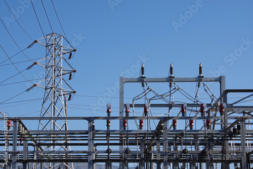 Close sectional view of the equipment of an electricity substation and a distribution tower with power lines