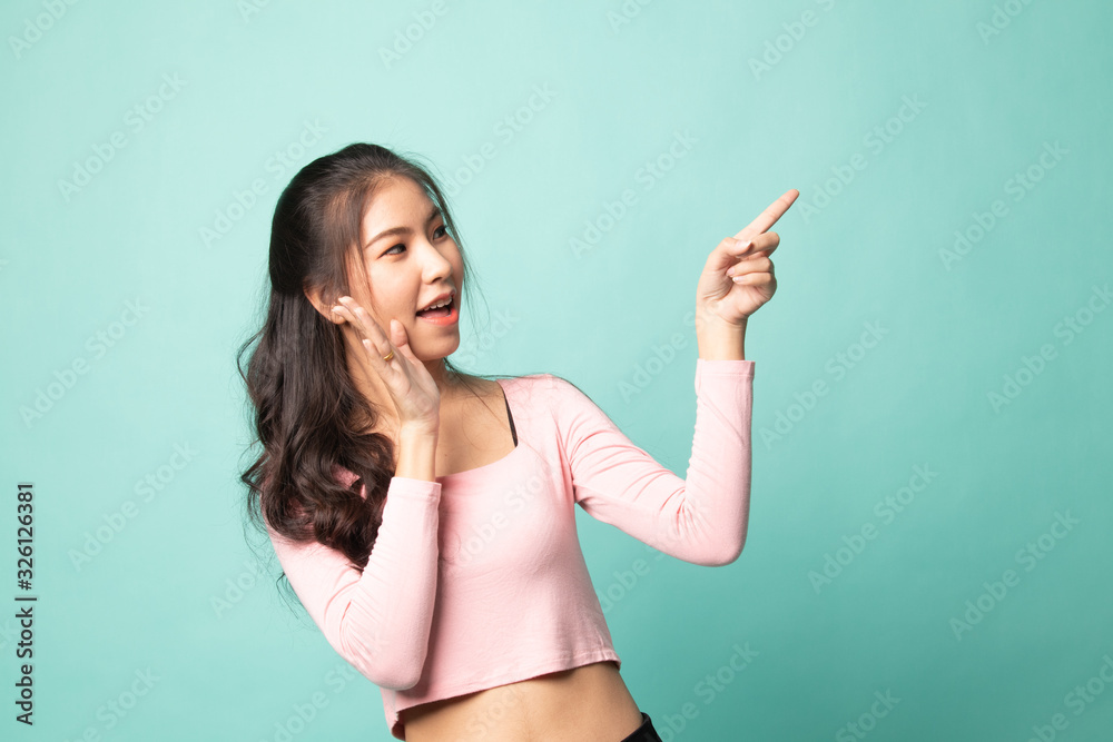 Fototapeta premium Excited Asian woman point to blank space.