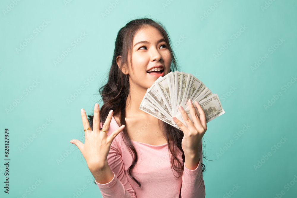 Portrait of young asian woman showing bunch of money banknotes. Portrait of young asian woman showing bunch of money banknotes.