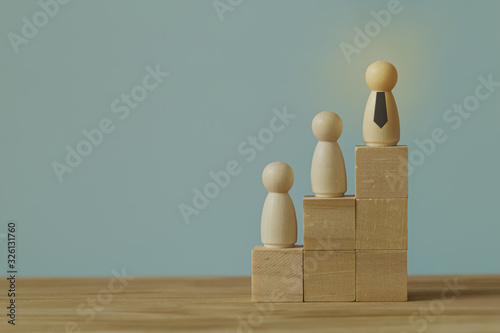 Successful business team leader concept: Businessman standing at the highest point on Wooden block. depicts of career growth up or business success.