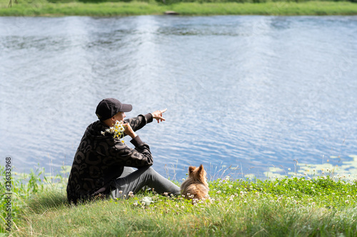 Fototapeta Naklejka Na Ścianę i Meble -  A woman with a dog on the lake in the summer.
