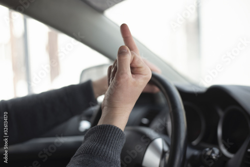 Angry driver is showing an obscene gesture close up.