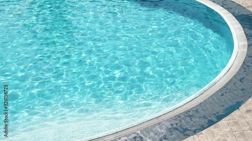 edge of the swimming pool with clear blue water at sunny summer day photo