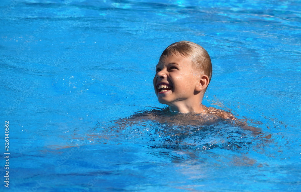 Child boy swimmer. The boy in the pool at the hotel. Sports holiday with children at the resort.