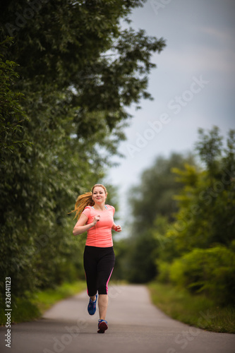 Young woman running outdoors on a lovely sunny winter/fall day © lightpoet