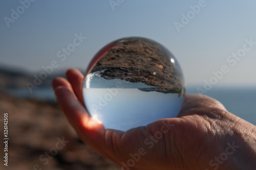 Esfera de cristal reflejando el horizonte del mar