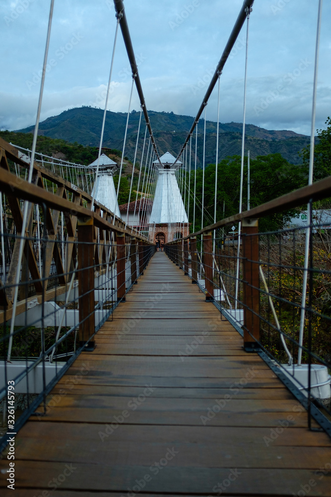 Obraz premium Suspended Bridge Connecting Olaya City and Santa Fe City, with Wooden Planks with a Pedestrian Part and another for Small Vehicles and Motorcycles