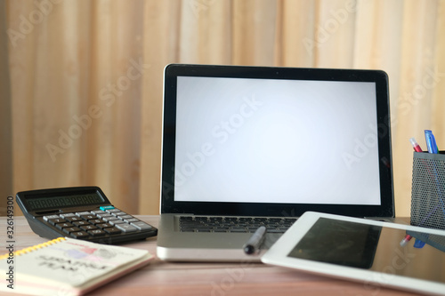 laptop  notepad and calculator on office desk 