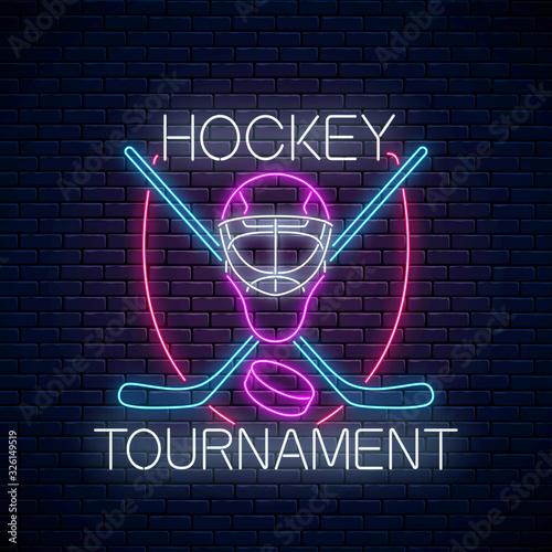 Hockey tournament neon sign with hockey sticks and puck and goalkeeper mask on dark brick wall background. Ice hockey competition logo, emblem, symbol design. Vector illustration.