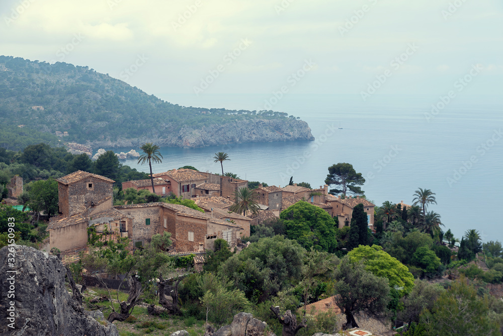 Beautiful view of mediterranean coastline in Llucalcari in Majorca island with stone houses Selective focus