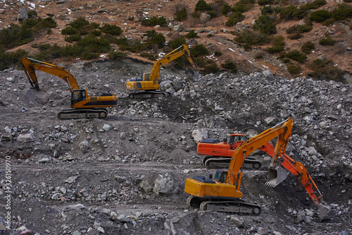 Four excavators digging ground together