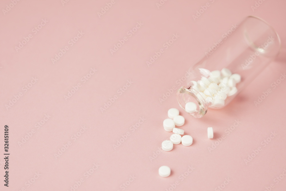 White medical pills in glass bottles,on pink background. Closeup photo of medical preparations with copy spaes. White medical pills in glass bottles,on pink background. Closeup photo of medical preparations with copy spaes.