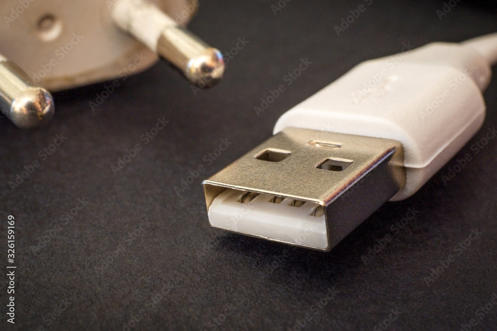 USB charger cable on black surface closeup often used for charging a smartphone or tablet USB charger cable on black surface closeup often used for charging a smartphone or tablet