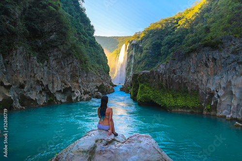 TAMUL, SAN LUIS POTOSI MEXICO - January 6, 2020:young women posing in River amazing crystalline blue water of Tamul waterfall photo