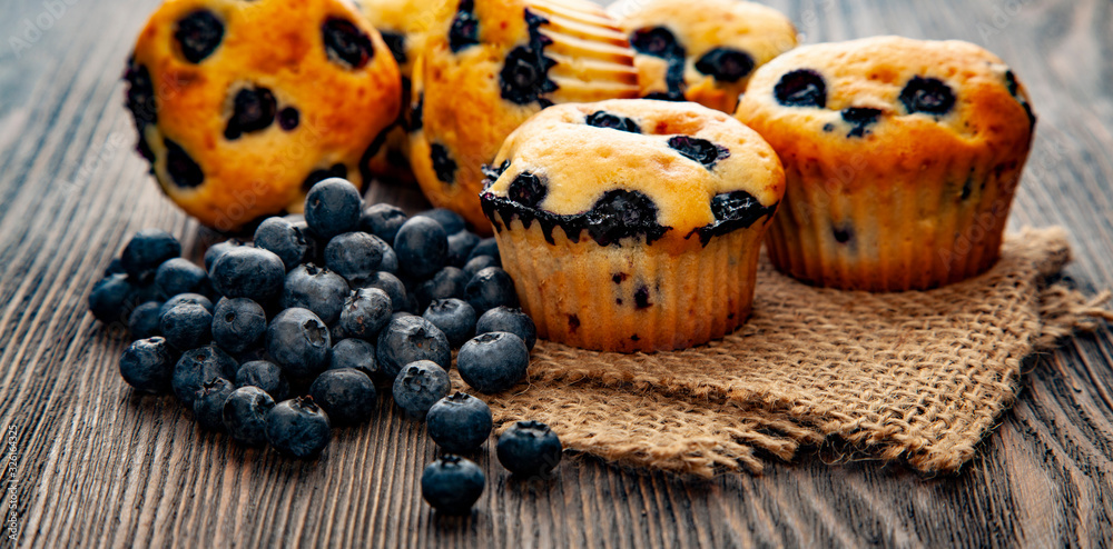 muffin with blueberries on a wooden table. fresh berries and sweet pastries on the board. muffin with blueberries on a wooden table. fresh berries and sweet pastries on the board.