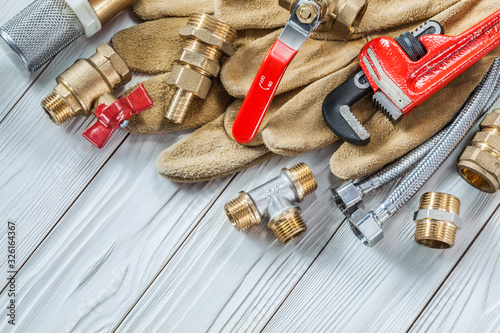 plumbing tools pipe fixtures and walves pipewrench on wooden boards photo