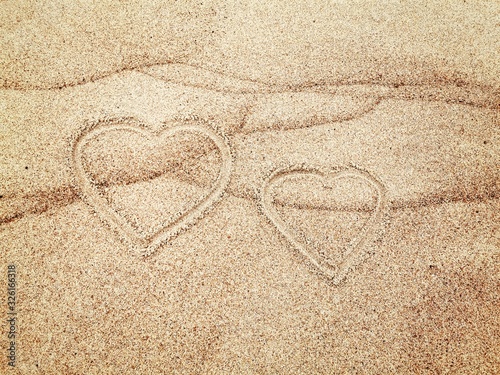 Two hearts painted on wet sand. Love concept. 