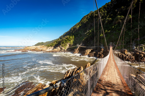 Suspension bridge in Tsitsikamma nation park, South Africa, with coast line in background