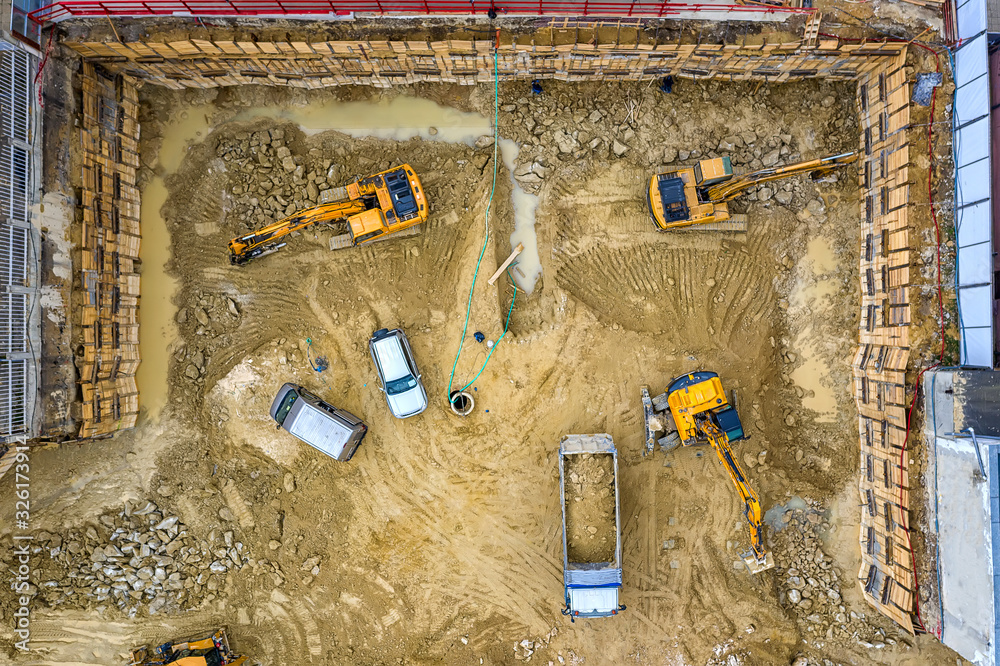 Heavy construction equipment working at the construction site. Aerial view from drone