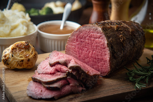 sliced eye of round beef roasted beef on cutting board photo