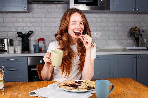 Woman eating cookie and drinking milk.