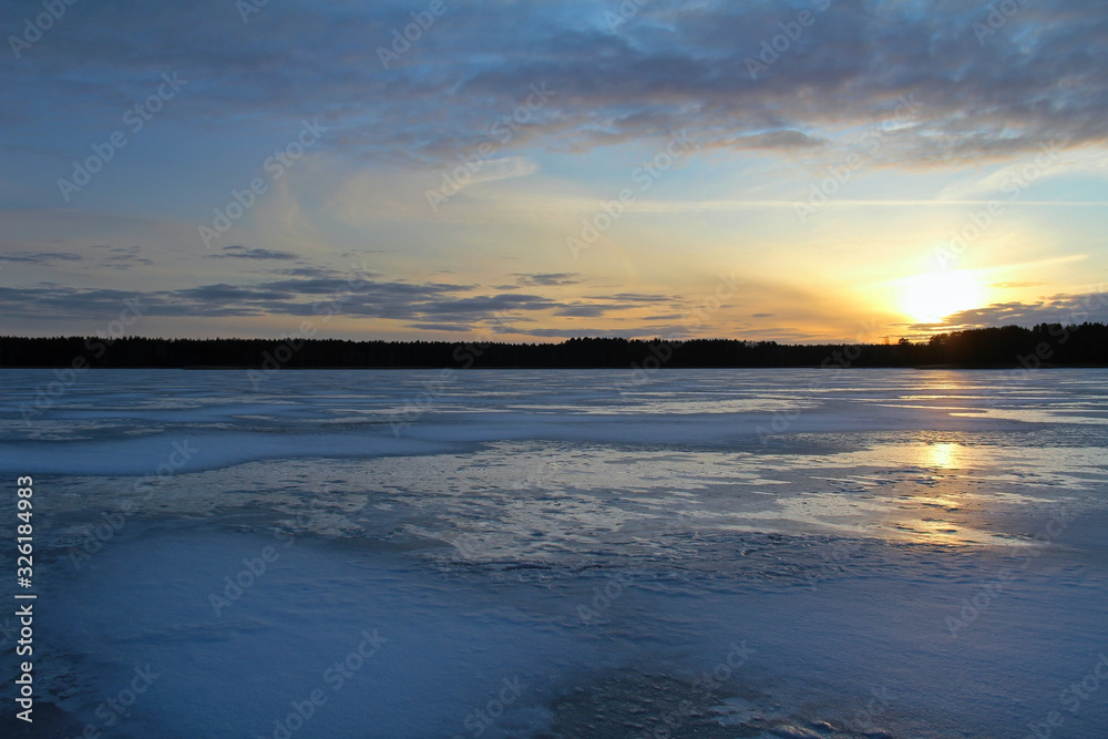 Winter landscape with beautiful frozen lake at sunset.