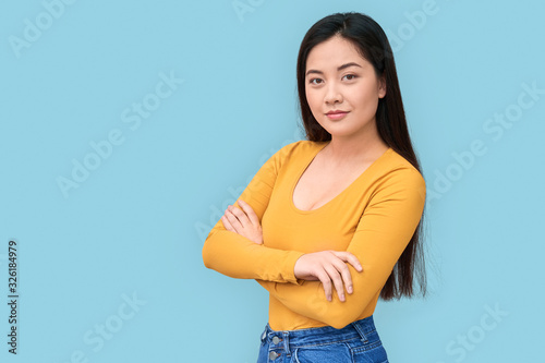 Young adult asian girl standing isolated on grey background